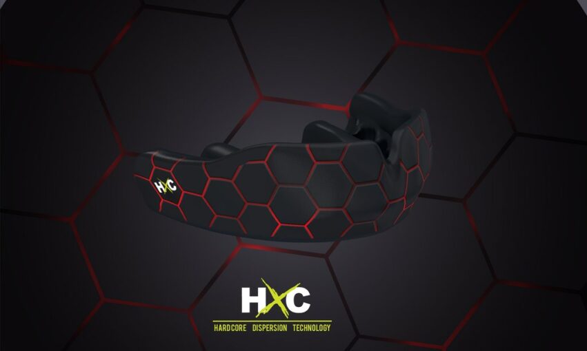A professional athlete holds a custom fit mouthguard featuring advanced HXC technology.