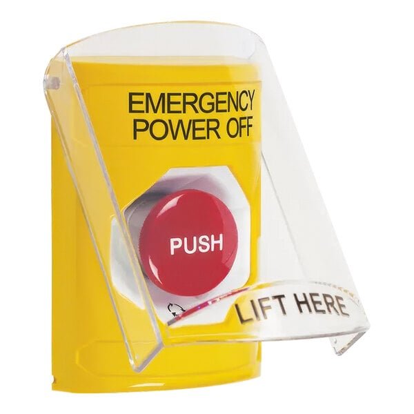 A technician reviewing safety documentation near an emergency power off button installation.