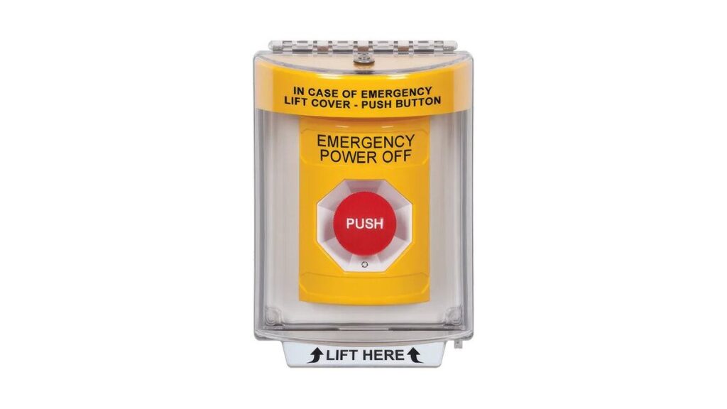 A red emergency power off push button mounted on an industrial wall.